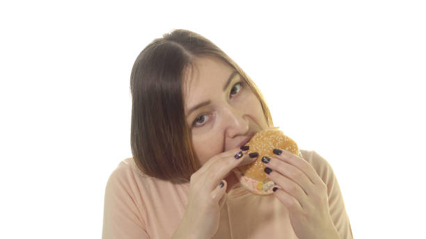 istock Young woman eating appetizing burger 1011834876