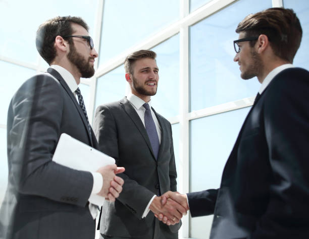 istock handshake business partners behind the glass wall 1011838568