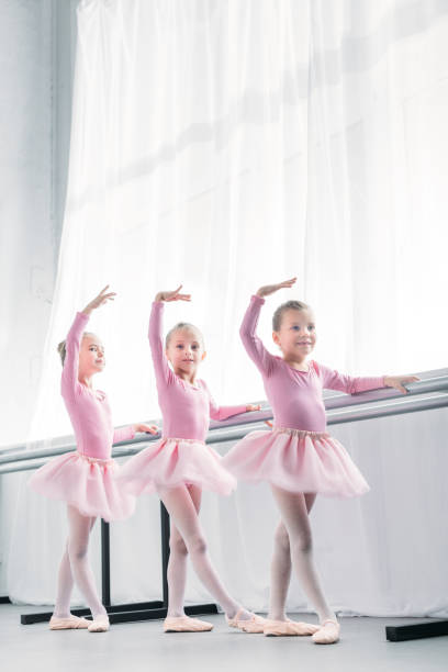 istock low angle view of beautiful little ballerinas dancing in ballet studio 1011838628