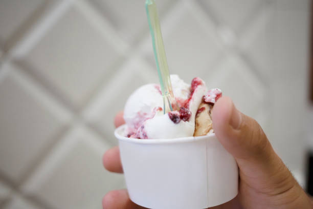 istock Hand holding ice cream served in takeaway cup in Trieste , Italy. 1011838712