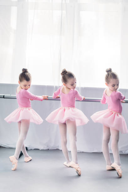 istock back view of graceful little ballerinas practicing ballet in studio 1011838876