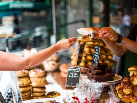 Cliente pagar pasteles dulces utilizando dinero en efectivo en el mercado de alimentos photo