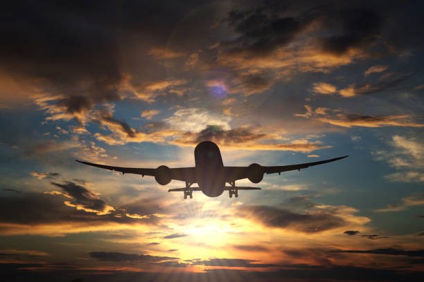 istock An airplane flying against the setting sun 3 1011844822