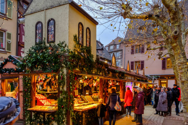 Tourists at the traditional Christmas market in the old town of Colmar, a city located in the cultural and historical region of Alsace, eastern France, renowned for its well-preserved historic centre.