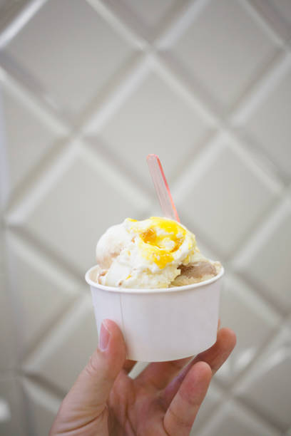 istock Hand holding ice cream served in takeaway cup in Trieste , Italy. 1011848222
