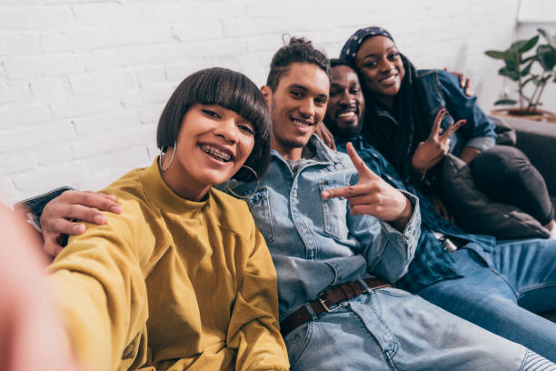 istock young mixed race woman taking selfie with multiethnic friends doing peace gesture 1011852214
