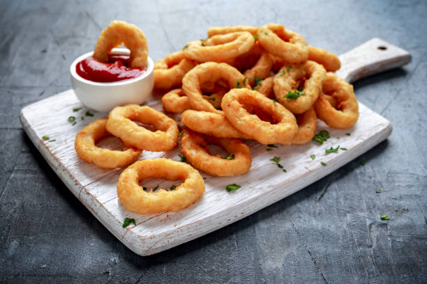 istock Fried Onion Rings with Ketchup on white cutting board 1011856208