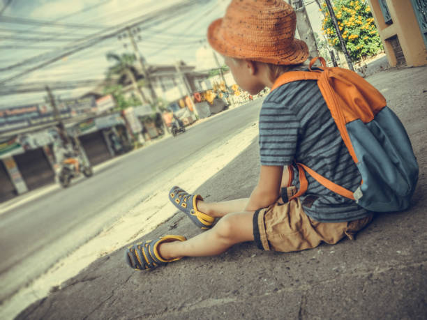 istock The boy sits on the asphalt 1011857596