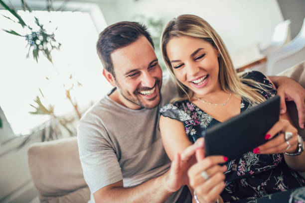 istock Attractive happy married couple using digital tablet at home. 1011857934