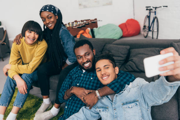 istock group of young multicultural smiling friends taking selfie on couch 1011857980