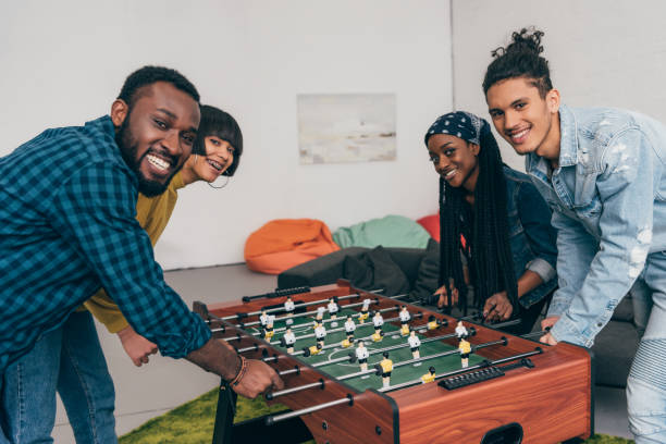 istock smiling group of multicultural friends playing table football 1011858004