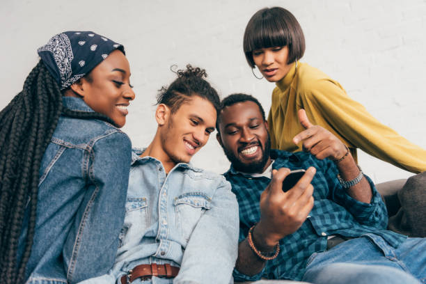 istock young black man pointing at smartphone screen to smiling friends 1011860120
