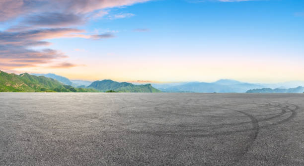 istock Empty asphalt square car tire brakes and mountain scenery 1011870724