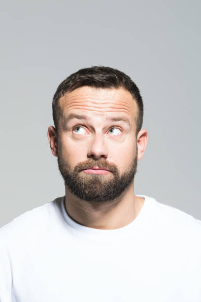istock Headshot of disappointed bearded young man, grey background 1011870798