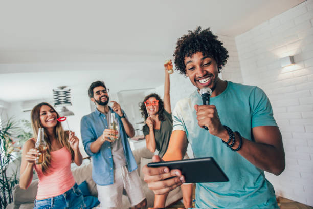 istock Group of friends playing karaoke at home 1011870842