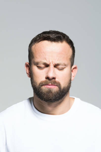 istock Headshot of pensive bearded young man, grey background 1011871116