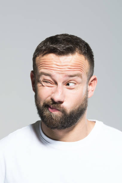 istock Headshot of confused bearded young man, grey background 1011871198