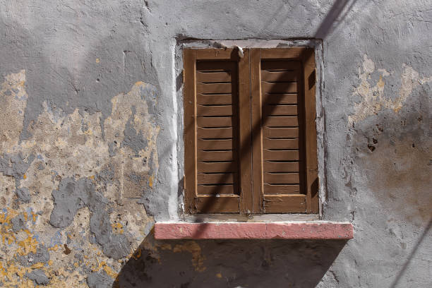 istock Window of an old house with a closed shutter 1011871378