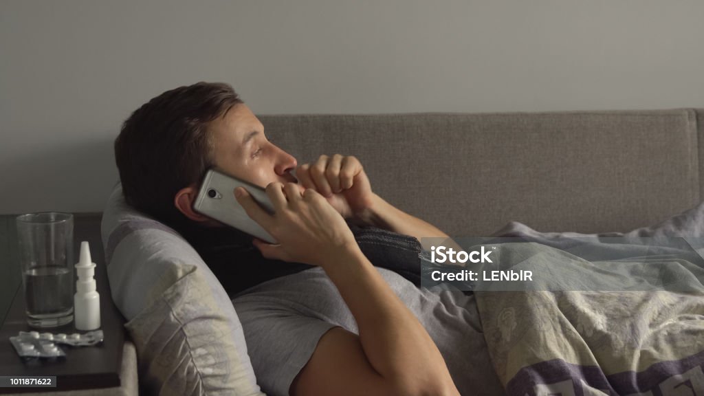 Kranker Mann im Bett neben seiner Medikamente in seinem Hause am Telefon zu sprechen. Menschen Sie leiden kalt und Winter-Grippe-virus - Lizenzfrei Krankheit Stock-Foto