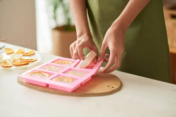 Close-up image of woman taking homemade soap out of silicone mold