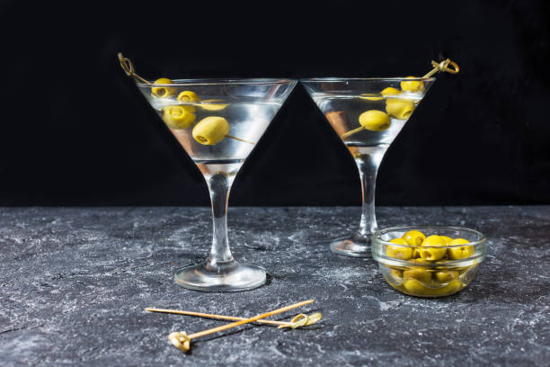 istock Martini cocktail with green olives on stone table background. 1011900220