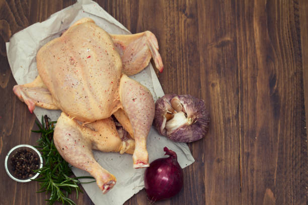 istock raw chicken with herbs and garlic on wooden background 1011905600