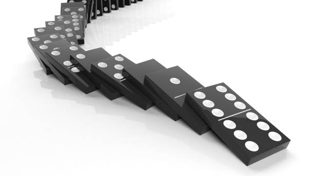 istock Black domino tiles falling in a row, isolated on white 1011906162