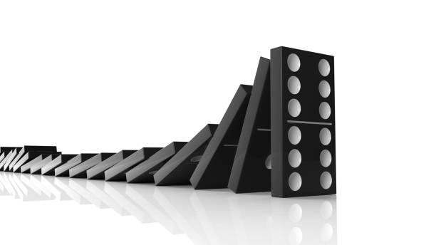 istock Black domino tiles falling in a row on to last one standing, isolated on white 1011906268