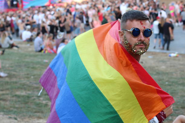 istock Man with glitter beard holding rainbow flag 1011906306