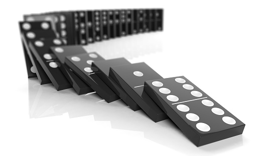 Black domino tiles falling in a row, isolated on white