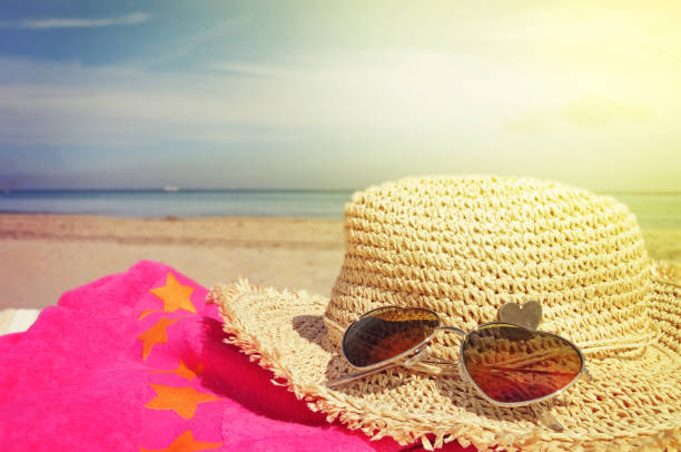 istock heart shaped sunglasses and straw hat on tropical beach 1011915486