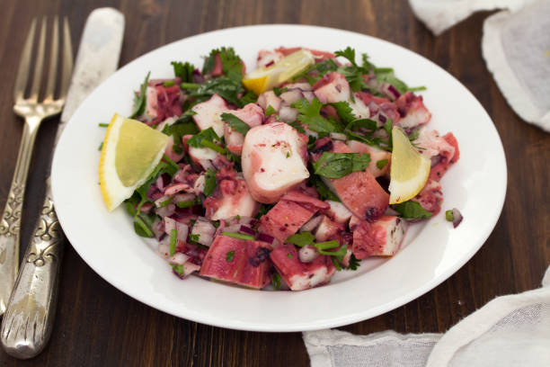 istock octopus salad with lemon on white dish on wooden background 1011915800