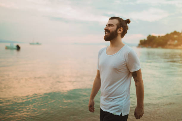 Young bearded man enjoying day at the beach during his vacation