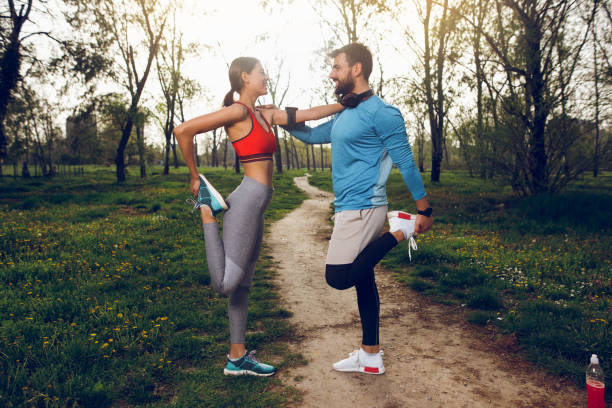 istock Fit athlete couple doing stretching exercises on running track 1011927428
