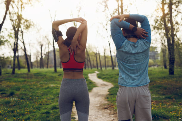istock Fit athlete couple doing stretching exercises on running track 1011930928