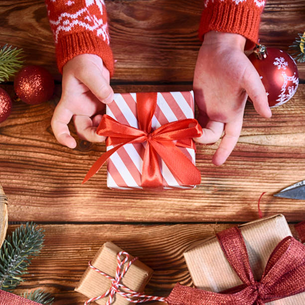 istock Chillds hand with christmas gift box, Christmas Holiday background 1011954014