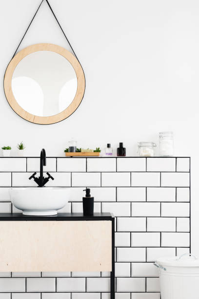istock Round mirror above white cabinet in simple bathroom interior. Real photo 1011954884