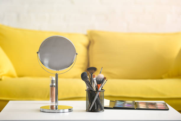 istock close up view of yellow sofa, mirror, makeup brushes and cosmetics on coffee table 1011964568