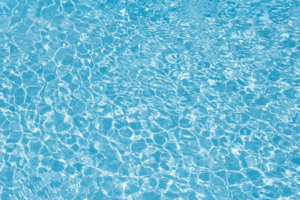 istock Blue water in pool for background and abstract, Ripple wave with sun reflection in swimming pool, Clean and bright purified water for healthy swimming 1011965092