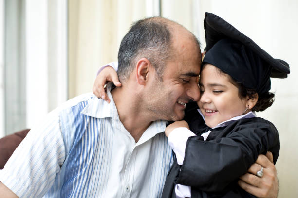 istock Father embracing little graduate 1011969866