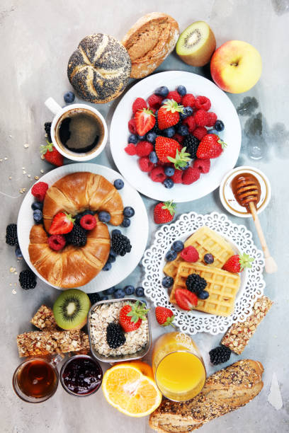 istock breakfast on table with waffles, croissants, coffe and juice. 1011970812