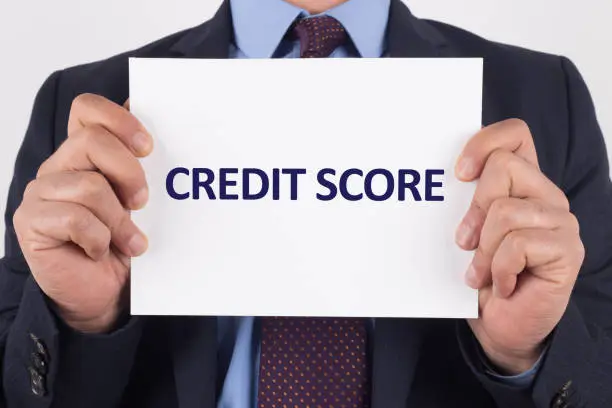 Photo of Man showing paper with CREDIT SCORE text