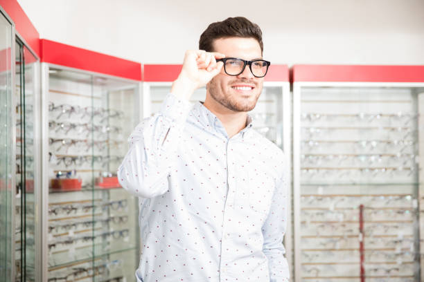 istock Handsome man chooses spectacle frames in the optical salon 1011971452