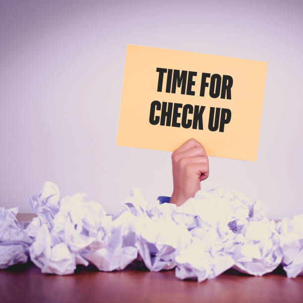 istock HAND HOLDING YELLOW PAPER WITH TIME FOR CHECK UPCONCEPT 1011972156