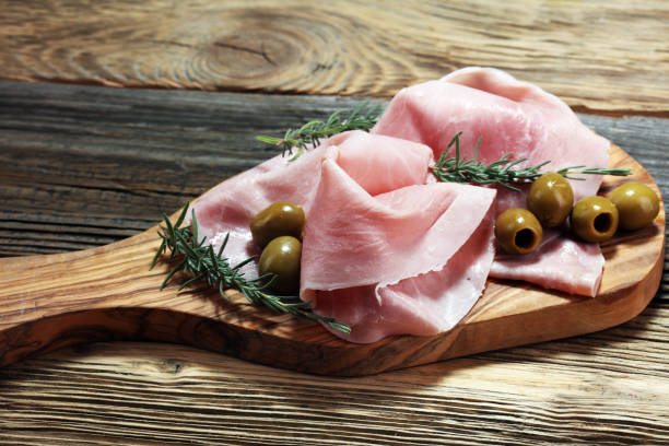 istock Sliced ham on wooden board. Fresh prosciutto. Pork ham sliced. 1011974740