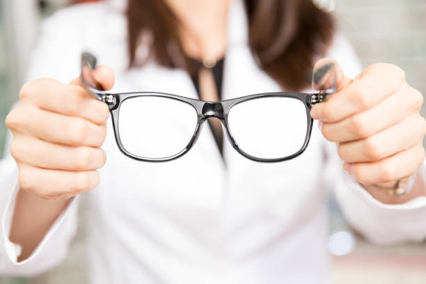 istock Woman optician holding black frame eyeglasses in hand 1011978614