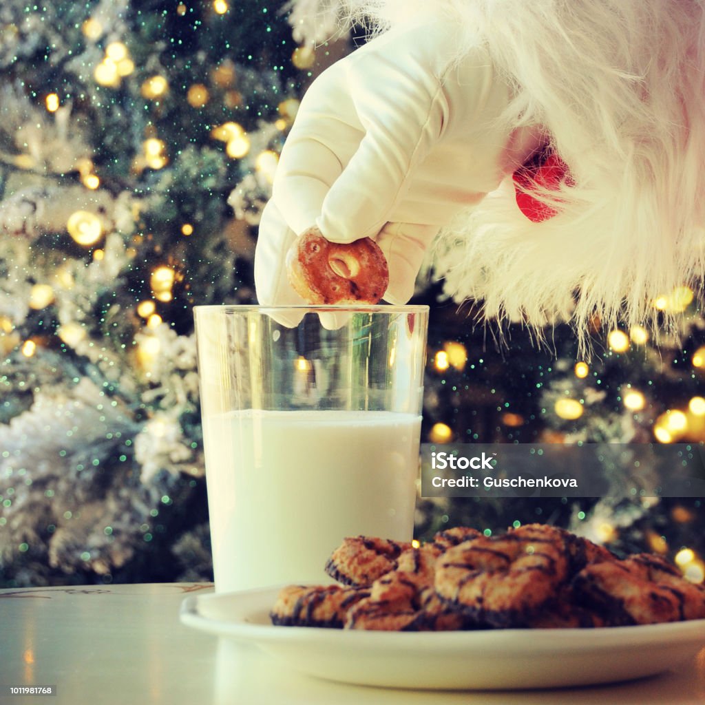 Hand of santa claus picking cookie on the table at home Milk Stock Photo