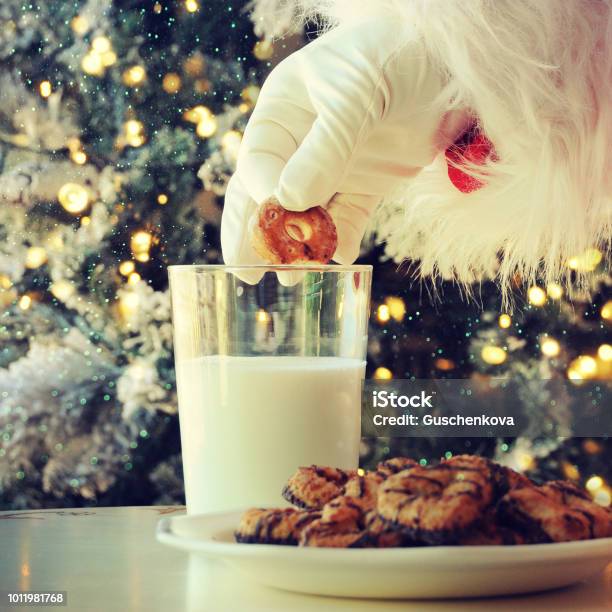 Hand Of Santa Claus Picking Cookie On The Table At Home Stock Photo - Download Image Now