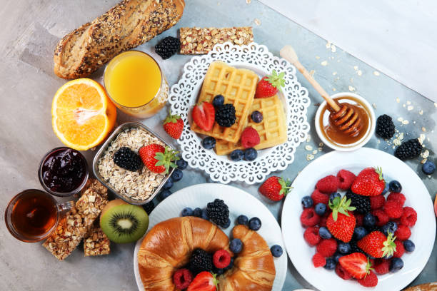 istock breakfast on table with waffles, croissants, coffe and juice. 1011982358