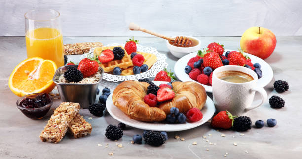 istock breakfast on table with waffles, croissants, coffe and juice. 1011982566